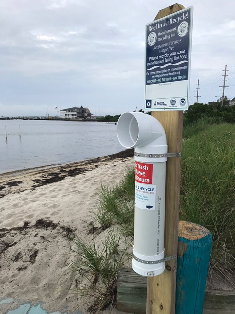 A sign mounted on a post near the beac
